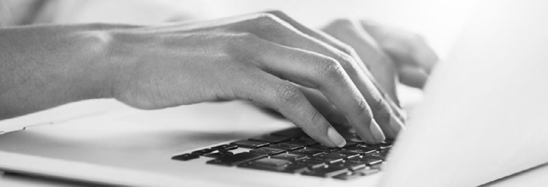 Mains sur le clavier d’un ordinateur portable